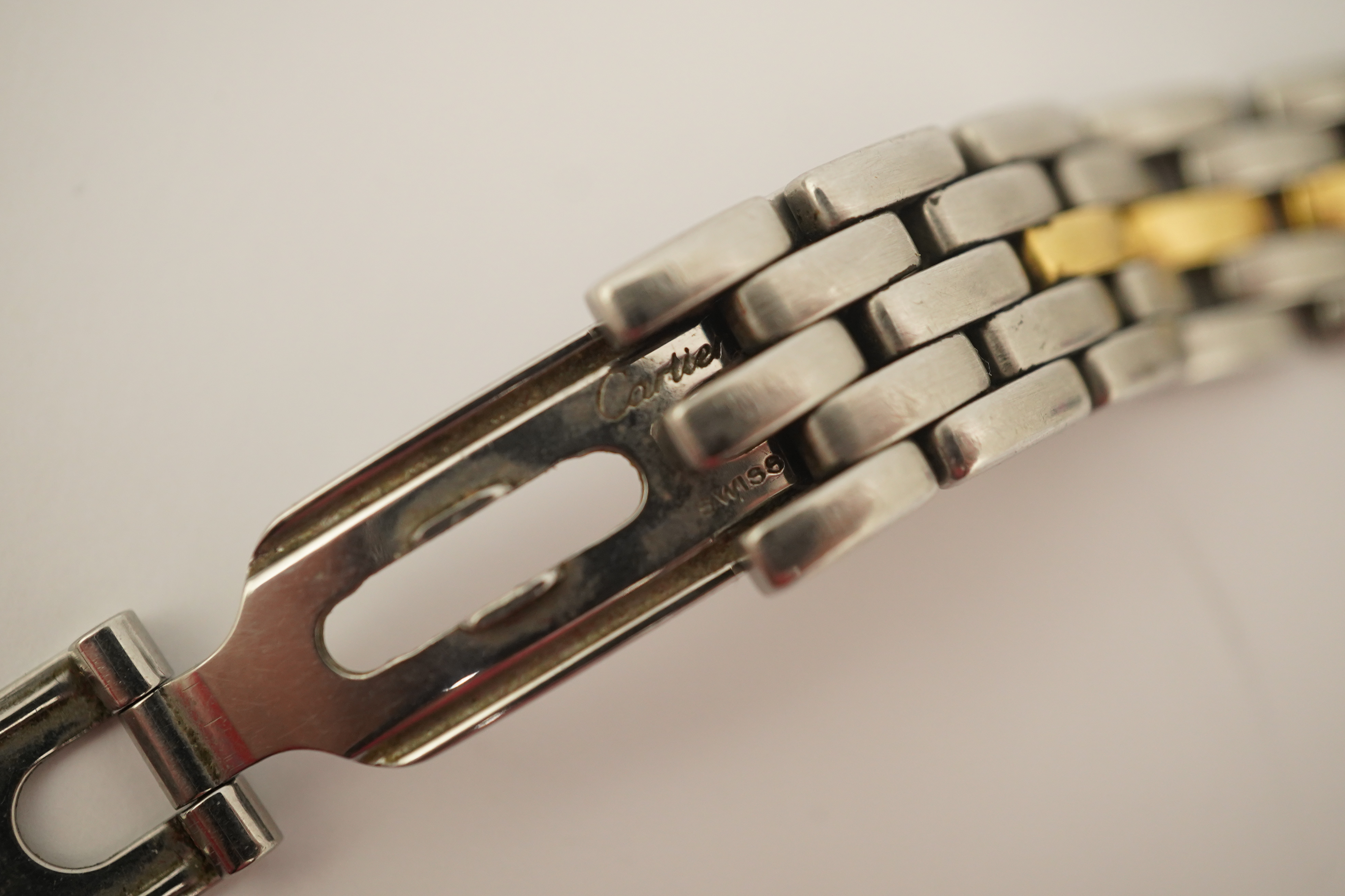 A lady's steel and gold Cartier Panthere quartz wrist watch, now on an associated leather strap, but with original Cartier steel and gold bracelet (lacking end bars)